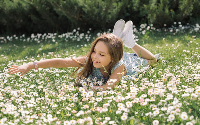 A girl plays in a wildflower lawn